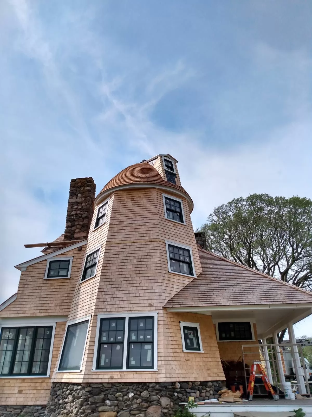 Cedar shake siding installed on a turret of a coastal home by Braun Construction in Centerville, MA